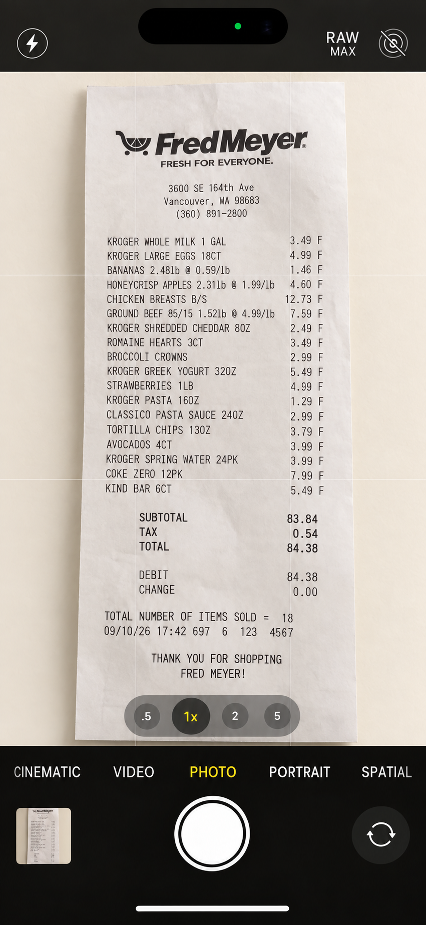 iPhone camera framing a Fred Meyer receipt with 18 items and a total of $84.38.